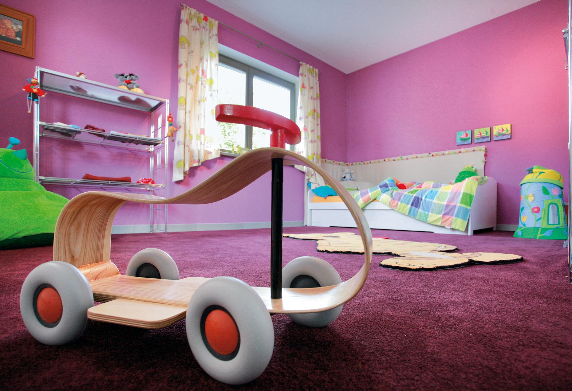 Colorida habitación infantil con paredes rosas y alfombras
