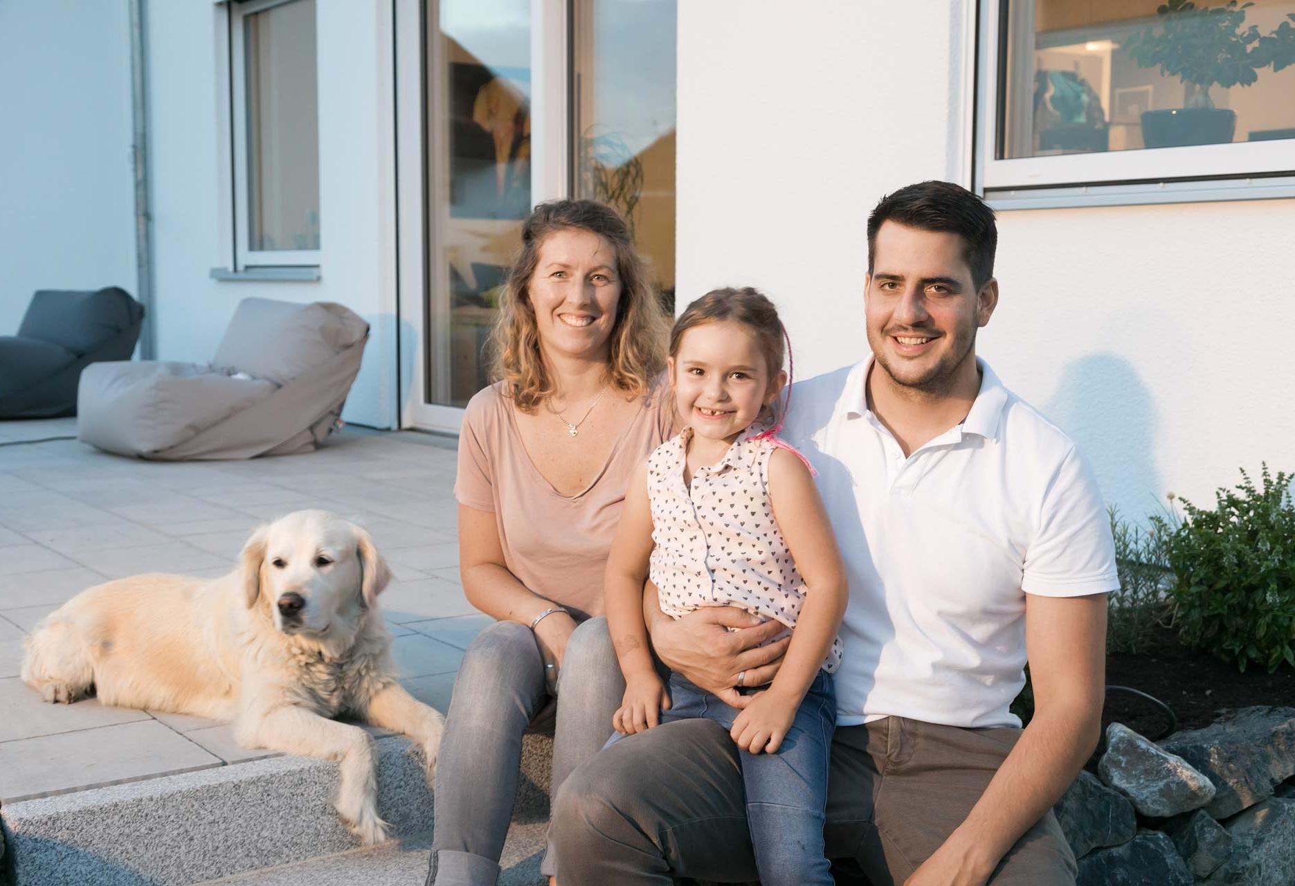 Glückliche Baufamilie mit Hund