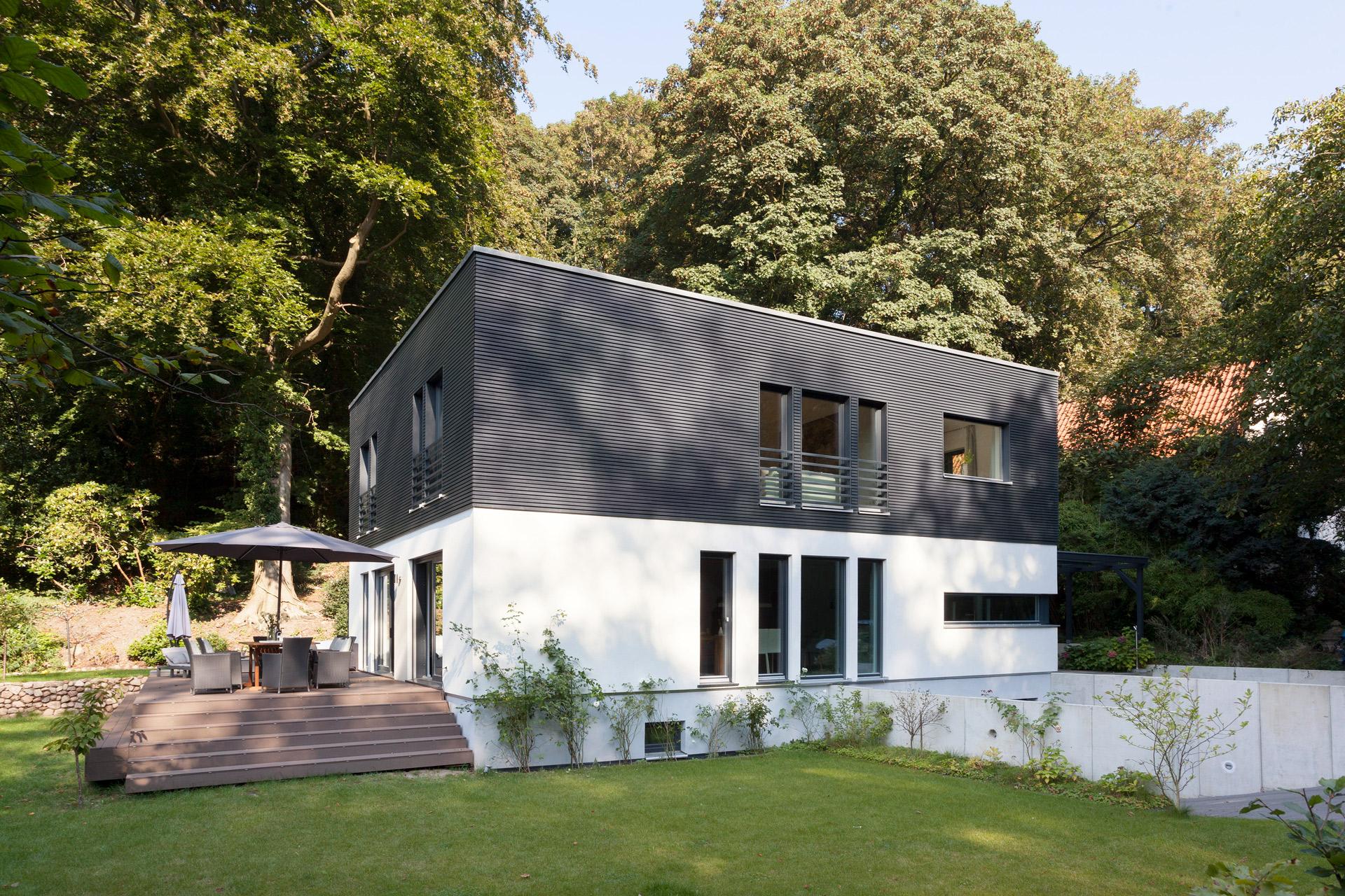 Casa Premium con techo plano y fachada de lamella oscura