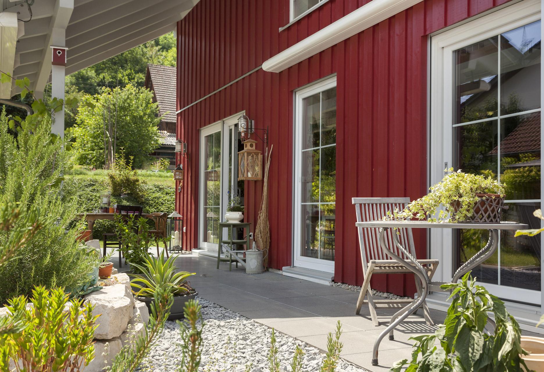 Maison préfabriquée avec revêtement en bois rouge et belle terrasse