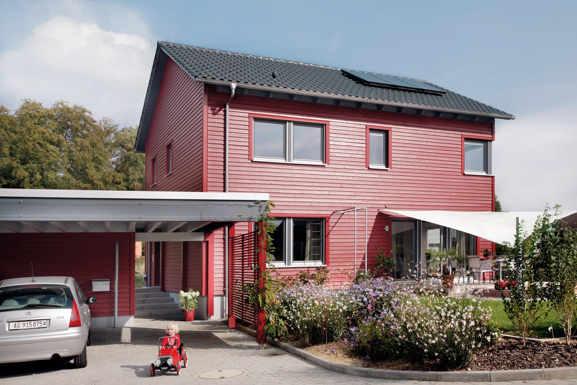 Casa con fachada de madera roja y techo inclinado