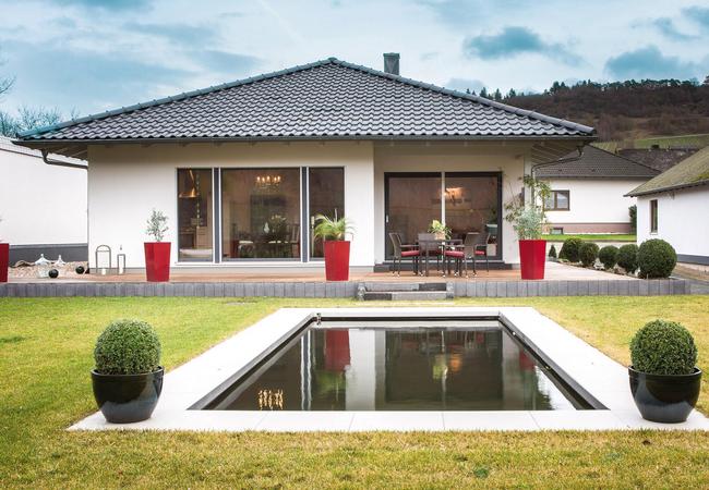 Bungalow moderne avec toit en croupe et étang de jardin