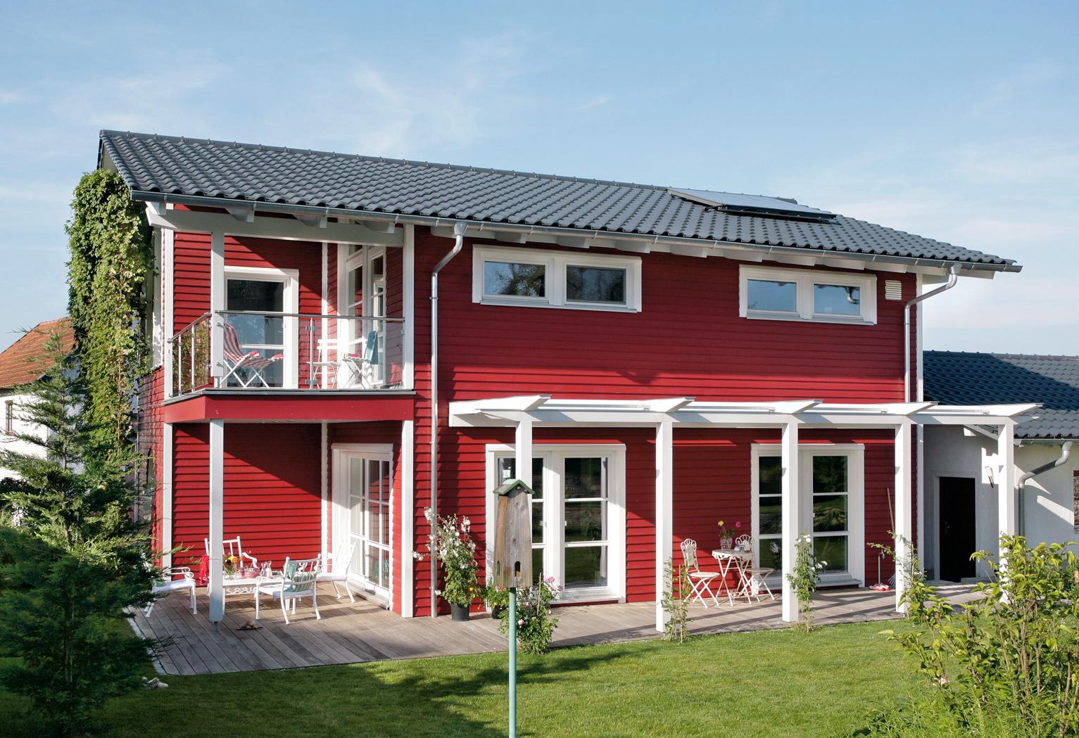 Detached house with red wooden facade in country style